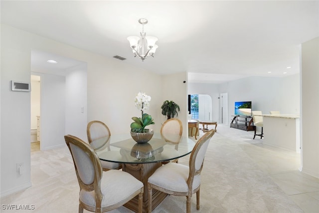 dining area featuring light colored carpet and a notable chandelier