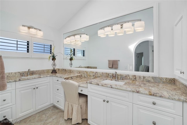 bathroom with tile patterned flooring, vanity, and lofted ceiling