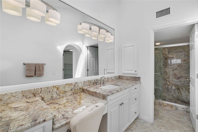 bathroom featuring tile patterned flooring, vanity, and walk in shower