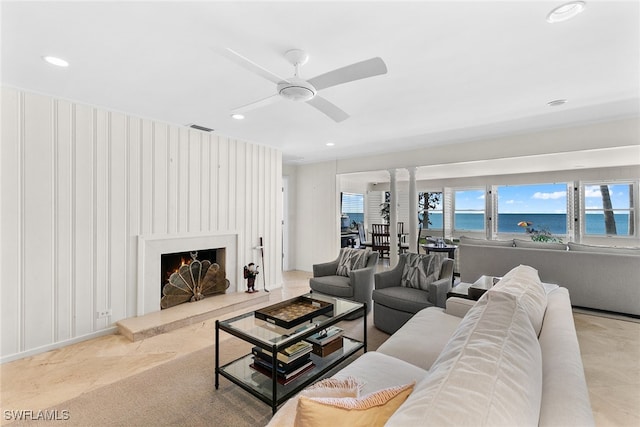 living room with a water view and ceiling fan