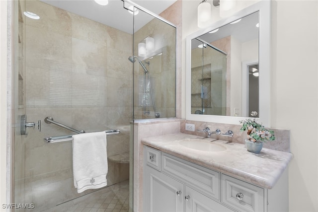 bathroom featuring vanity and a shower with door