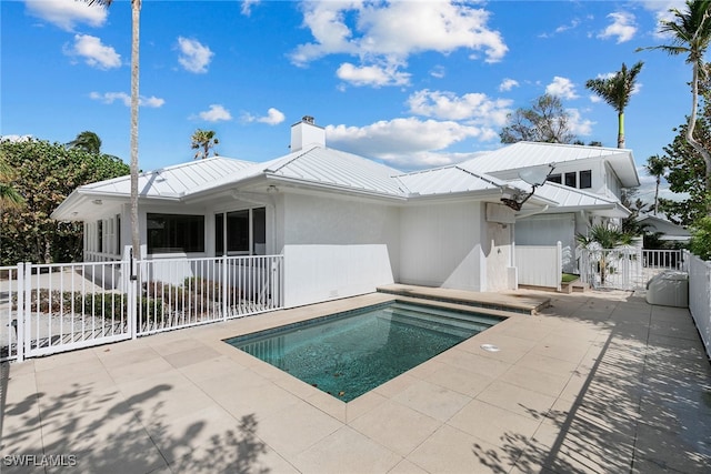 back of house with a fenced in pool and a patio area