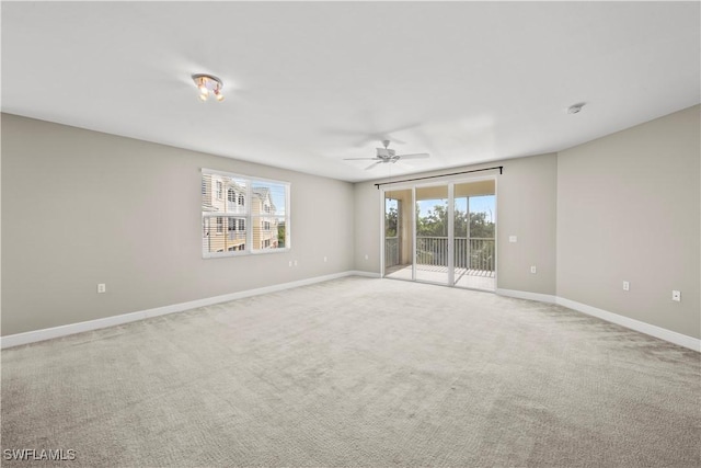 spare room featuring light carpet and ceiling fan