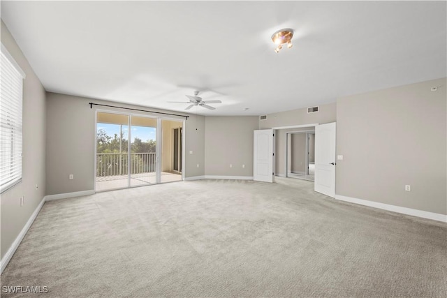 empty room featuring ceiling fan and light carpet