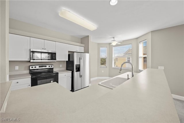 kitchen with white cabinets, appliances with stainless steel finishes, ceiling fan, and sink