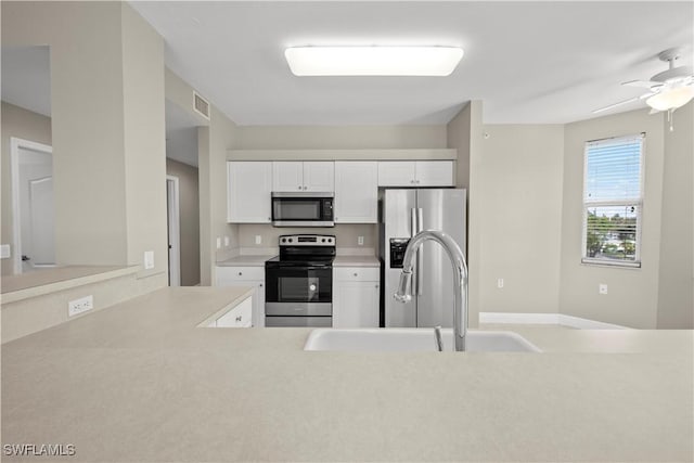 kitchen with white cabinets, ceiling fan, sink, and stainless steel appliances