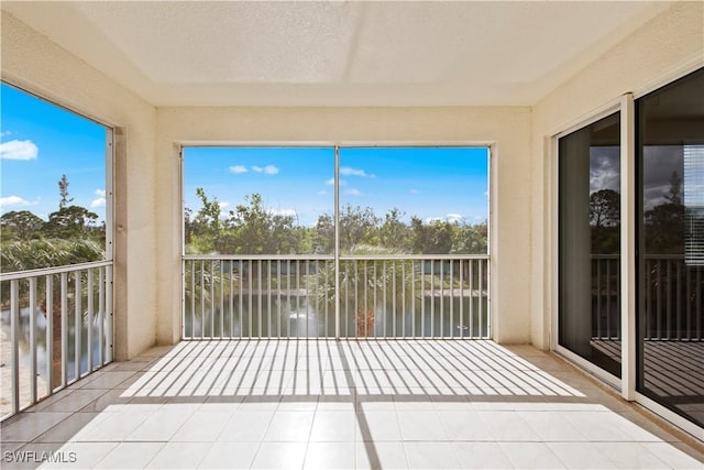 unfurnished sunroom featuring a water view