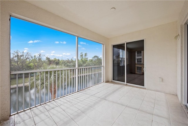 unfurnished sunroom featuring a water view