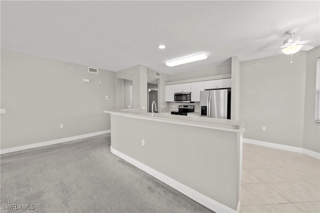 kitchen with ceiling fan, sink, an island with sink, white cabinets, and appliances with stainless steel finishes