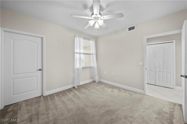 interior space with ceiling fan and light colored carpet