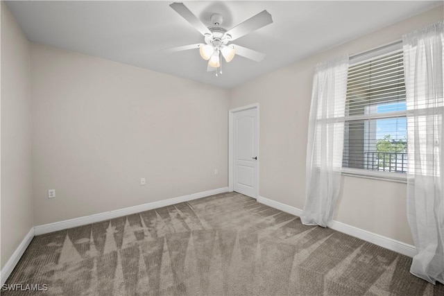 carpeted spare room featuring ceiling fan