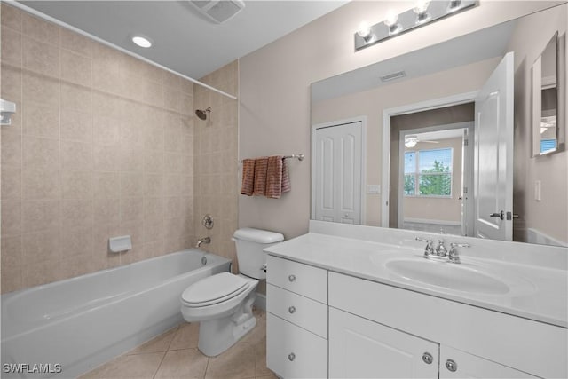 full bathroom with tile patterned flooring, tiled shower / bath combo, toilet, and vanity