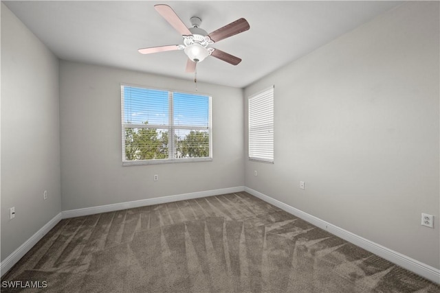 empty room featuring ceiling fan and dark carpet