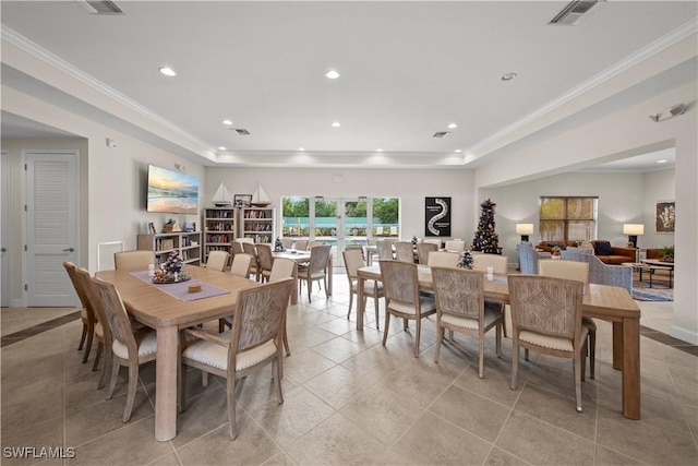 dining room with a raised ceiling, light tile patterned floors, and ornamental molding