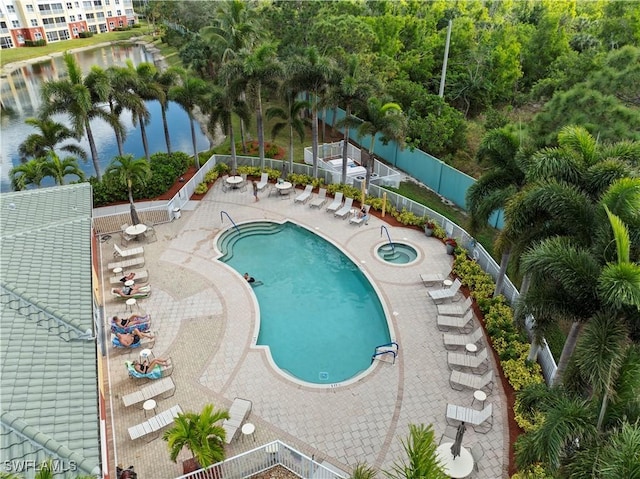 view of swimming pool with a patio area and a water view