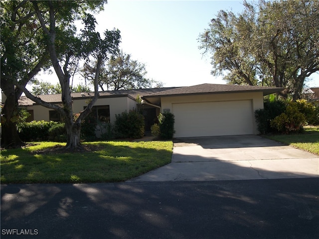 ranch-style home featuring a garage and a front yard