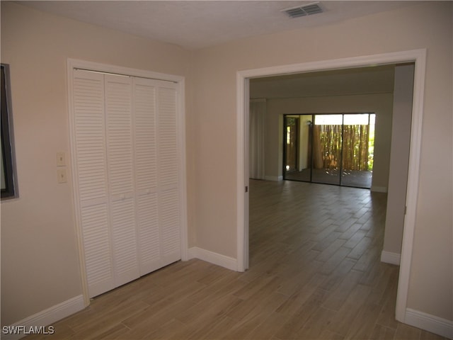 hallway with hardwood / wood-style floors