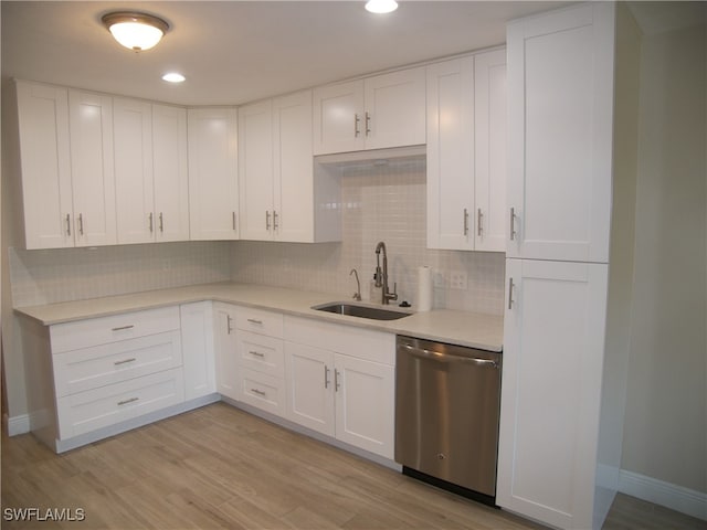 kitchen featuring white cabinets, light hardwood / wood-style floors, stainless steel dishwasher, and sink