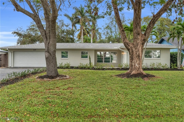 ranch-style house featuring a front lawn and a garage