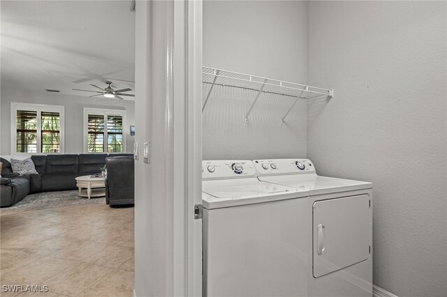 laundry room with washing machine and clothes dryer, ceiling fan, and light tile patterned floors