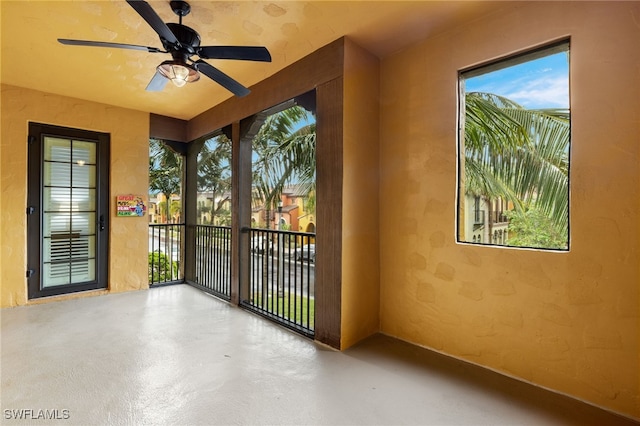 unfurnished sunroom featuring ceiling fan