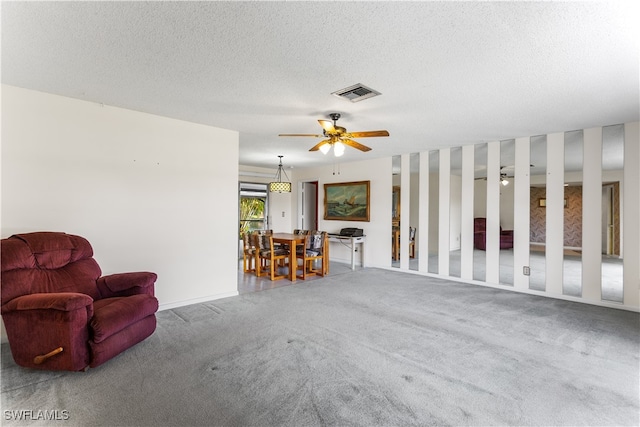 carpeted living room with ceiling fan and a textured ceiling