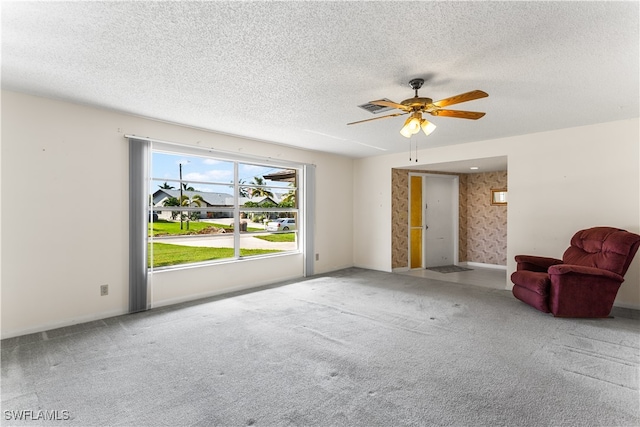 unfurnished living room with a textured ceiling, carpet, and ceiling fan