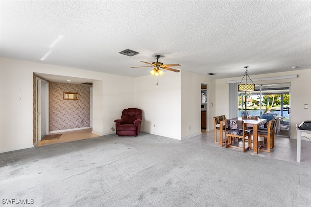 interior space featuring carpet flooring, a textured ceiling, and ceiling fan