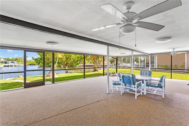 unfurnished sunroom featuring a water view and ceiling fan