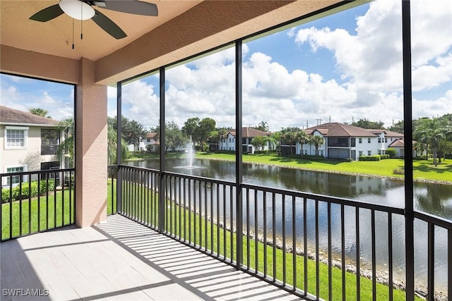 unfurnished sunroom with a water view and ceiling fan