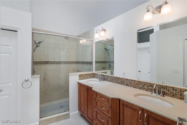 bathroom with vanity, tile patterned flooring, a shower with door, and backsplash