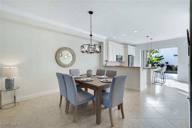 tiled dining room featuring a notable chandelier and crown molding