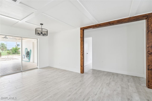 unfurnished room with beam ceiling, an inviting chandelier, and light hardwood / wood-style flooring