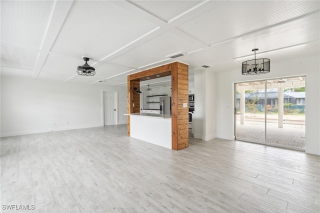 unfurnished living room with a notable chandelier and light hardwood / wood-style flooring