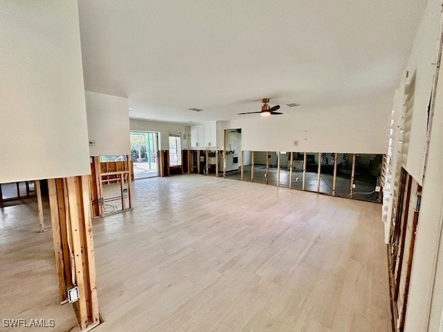 unfurnished living room featuring ceiling fan and light hardwood / wood-style flooring