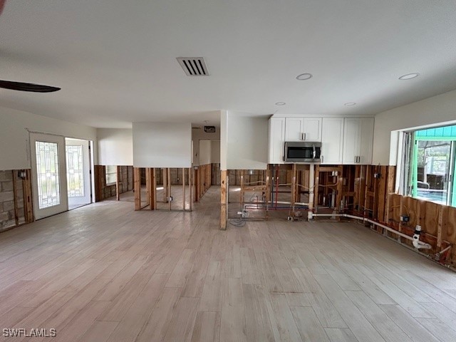 kitchen with white cabinets and light hardwood / wood-style flooring