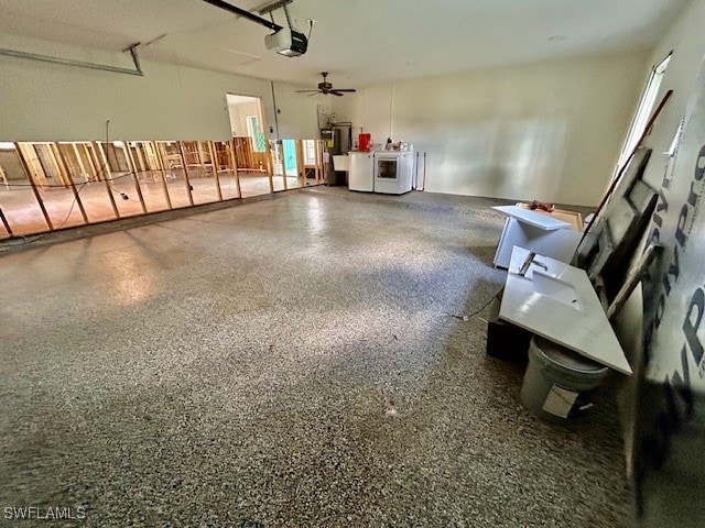 garage with a garage door opener, washer and dryer, and ceiling fan