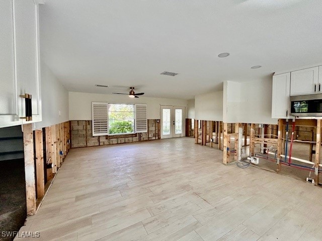 living room featuring ceiling fan, light hardwood / wood-style flooring, and french doors