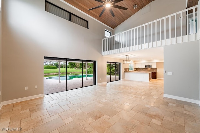 unfurnished living room featuring ceiling fan, a high ceiling, and wood ceiling