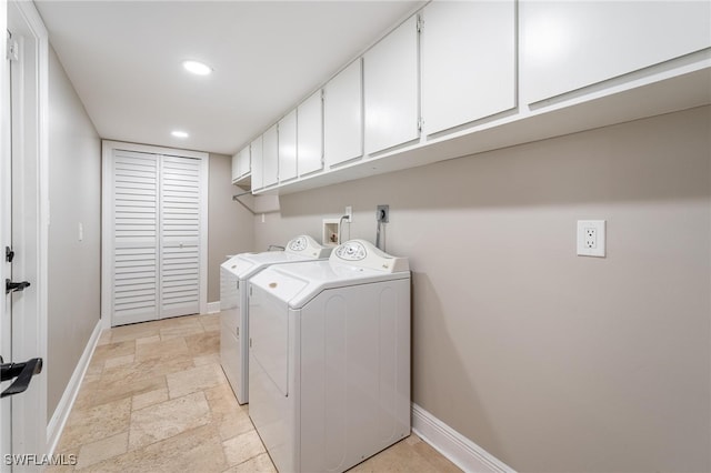 clothes washing area with cabinets and washing machine and clothes dryer