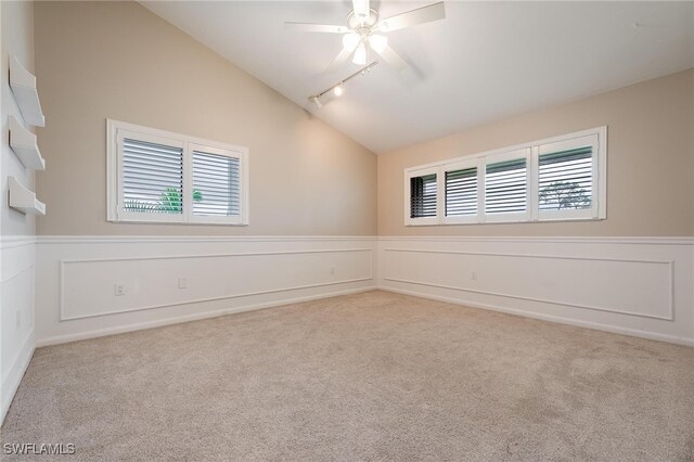 unfurnished room with a wealth of natural light, vaulted ceiling, and light carpet