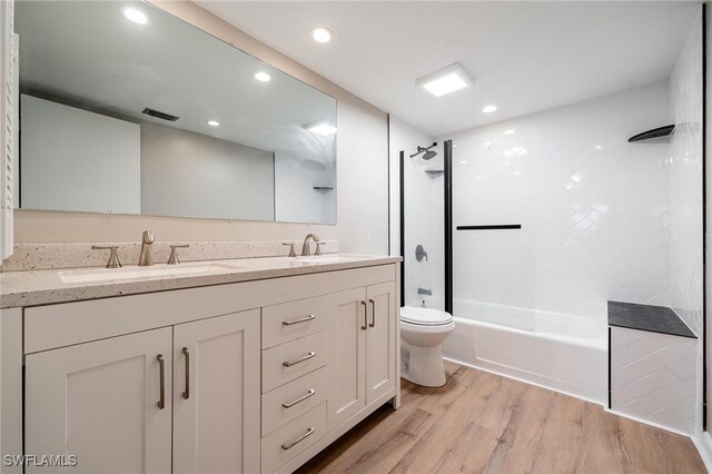 full bathroom with vanity, wood-type flooring, tiled shower / bath, and toilet