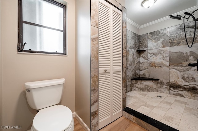 bathroom with hardwood / wood-style flooring, toilet, a tile shower, and crown molding