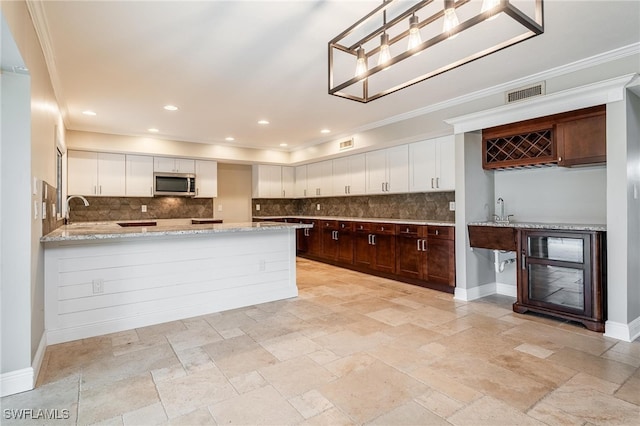 kitchen featuring dark brown cabinetry, white cabinets, backsplash, and kitchen peninsula