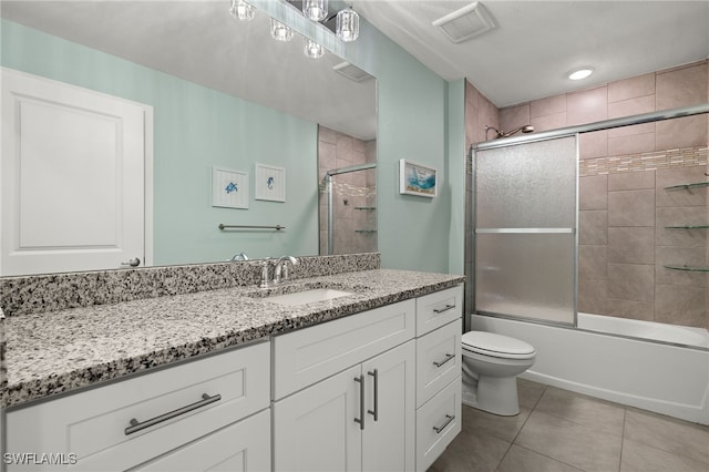 full bathroom featuring toilet, bath / shower combo with glass door, vanity, and tile patterned flooring