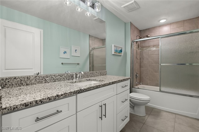 full bathroom featuring tile patterned flooring, vanity, combined bath / shower with glass door, and toilet