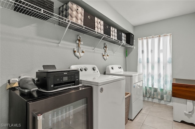 clothes washing area with washing machine and clothes dryer and light tile patterned floors