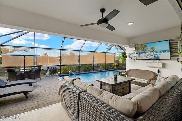 view of swimming pool with ceiling fan, a lanai, a patio, and an outdoor living space