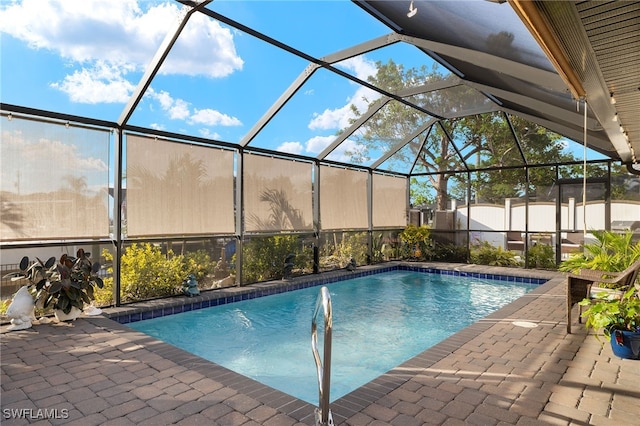 view of swimming pool with glass enclosure and a patio area