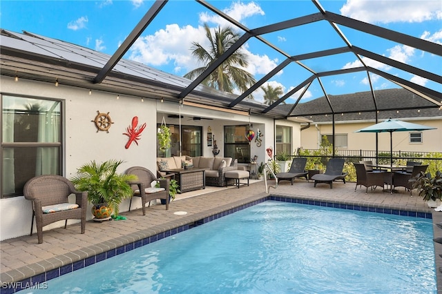 view of pool with a patio area, glass enclosure, and an outdoor living space